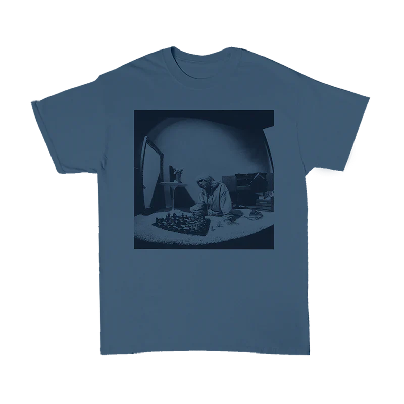 Blue T-shirt featuring a monochrome image of Billie Eilish playing chess, part of the Basics Collection from Billie Eilish merch.