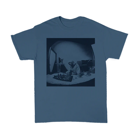 Blue T-shirt featuring a monochrome image of Billie Eilish playing chess, part of the Basics Collection from Billie Eilish merch.