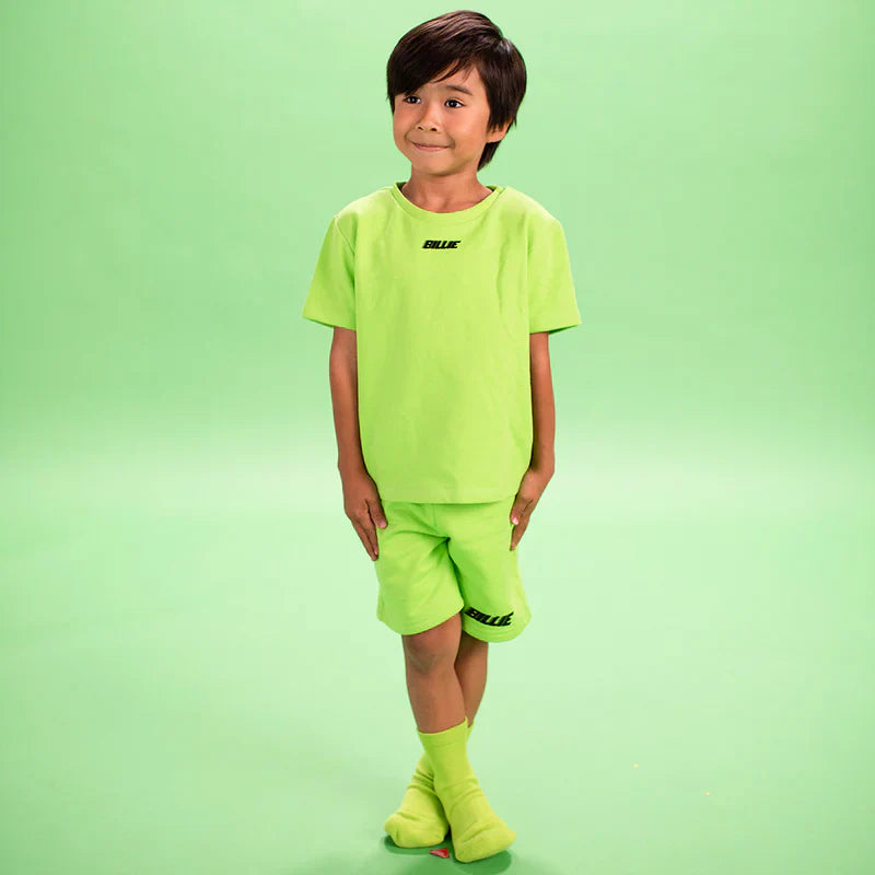 Child laughing and playing while wearing a bright green Billie T-Shirt and shorts from Billie Eilish merch