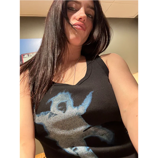 Billie Eilish wearing the Falling Ribbed Crop Tank featuring a falling figure graphic on a black tank top.